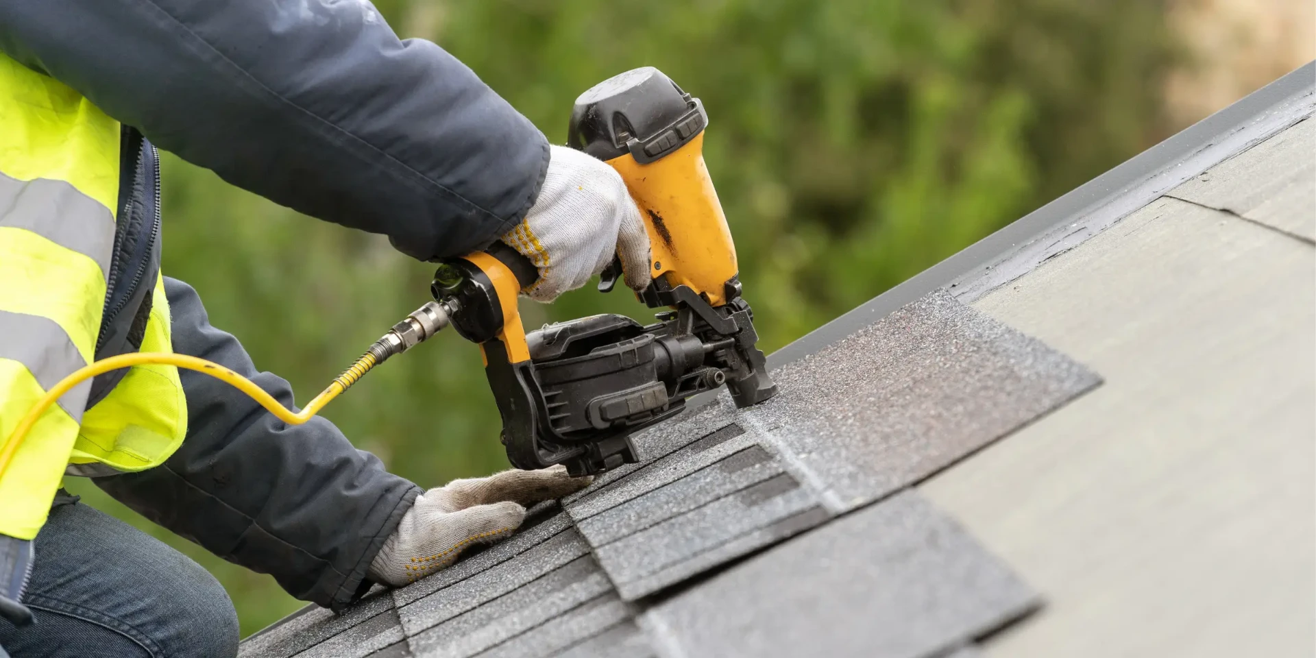 Roofer nailing new architectural shingles during a Central Florida re-roof