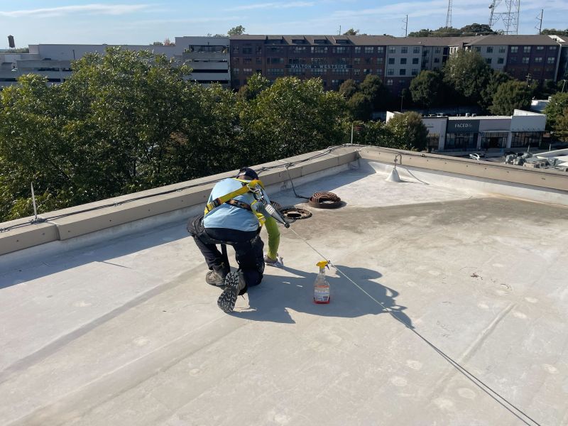 Technician inspecting a commercial flat roof membrane in Orlando, FL