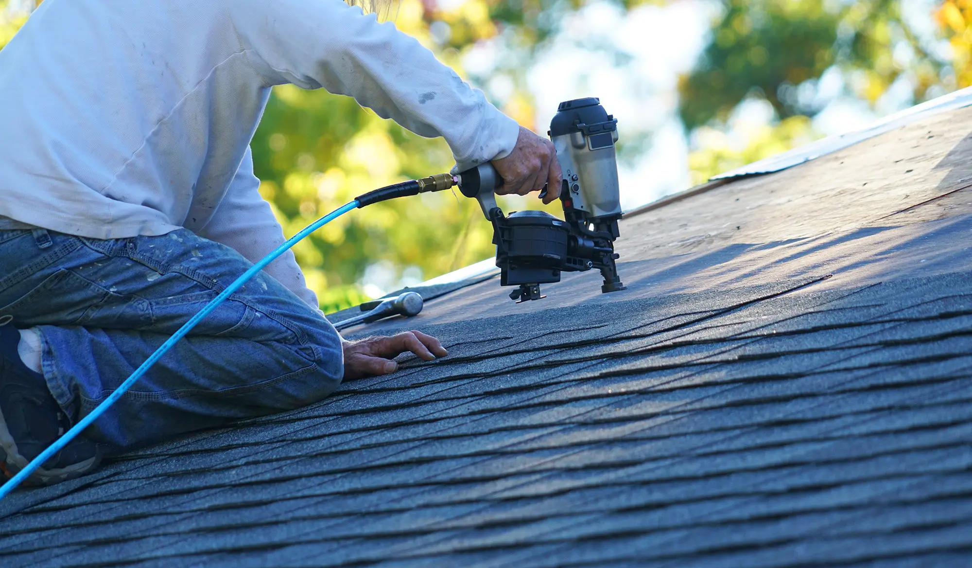 Roofer repairing damaged shingles and flashing on an Orlando, FL home