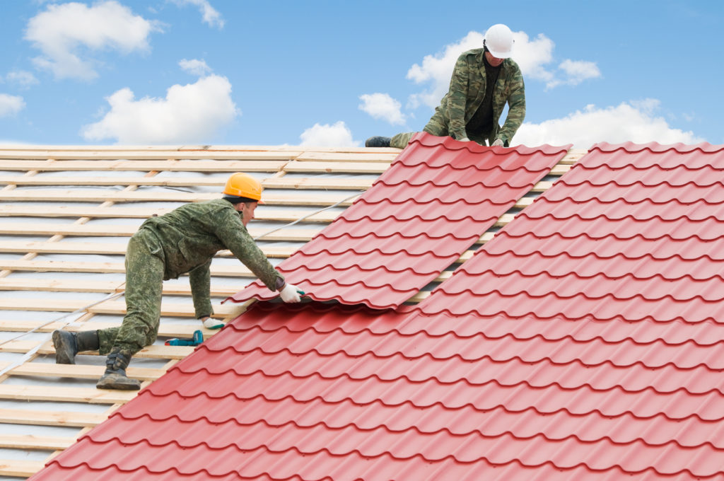 Roofing crew installing a new tile roof layer during a Central Florida re-roof